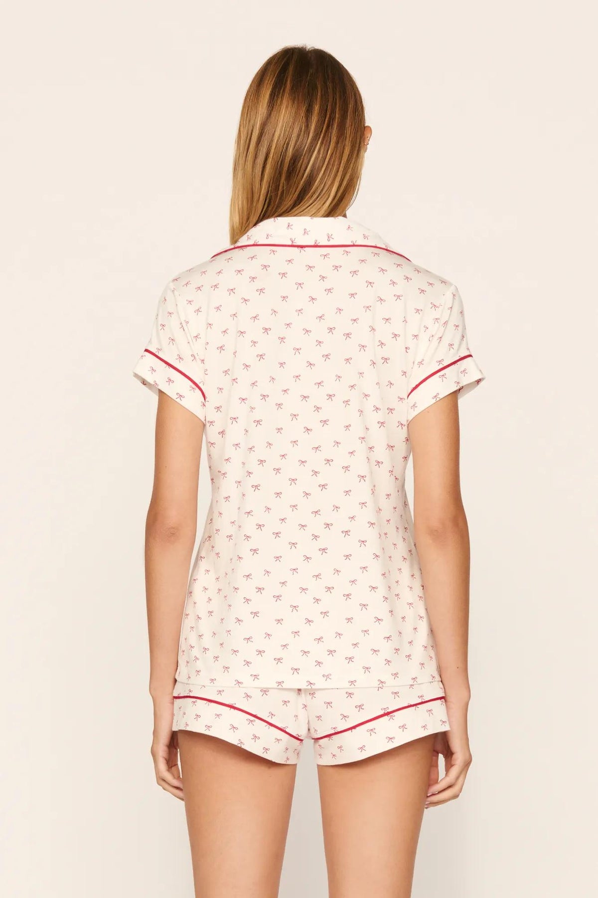 Model is wearing Gisele Printed TENCEL™ Modal Shortie Short PJ Set in Mini Bow Ivory/Holly Red