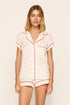 Model is wearing Gisele Printed TENCEL™ Modal Shortie Short PJ Set in Mini Bow Ivory/Holly Red