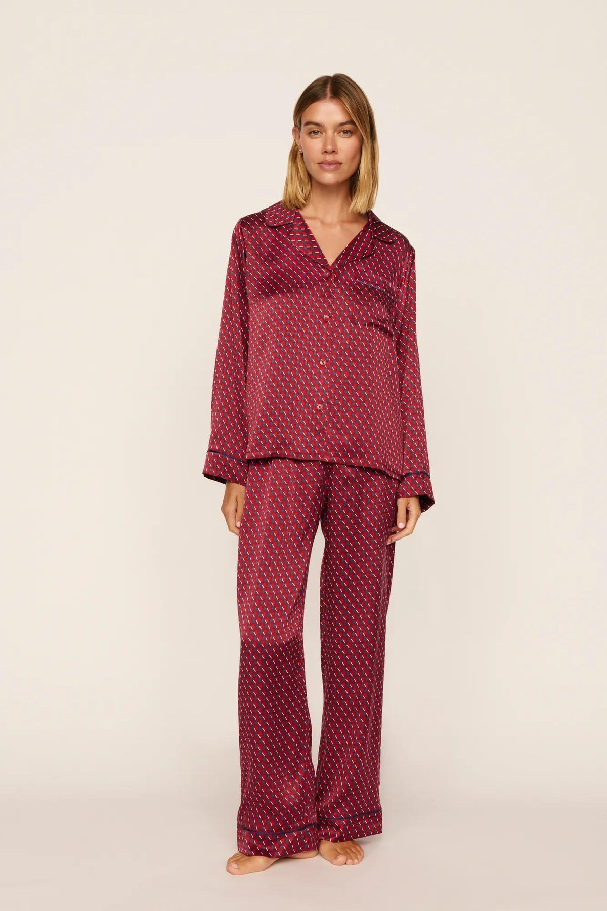 Model is wearing Inez Washable Silk Printed Long PJ Set in Harlequin Holly Red/Navy