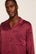 Model is wearing Charles Washable Silk Printed Long PJ Set in Harlequin Holly Red/Navy