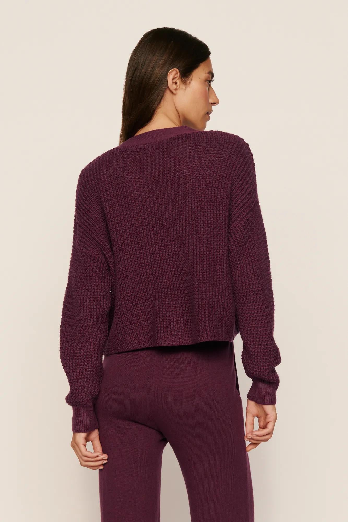 Model is wearing Recycled Sweater Cropped Cardigan in Wildberry