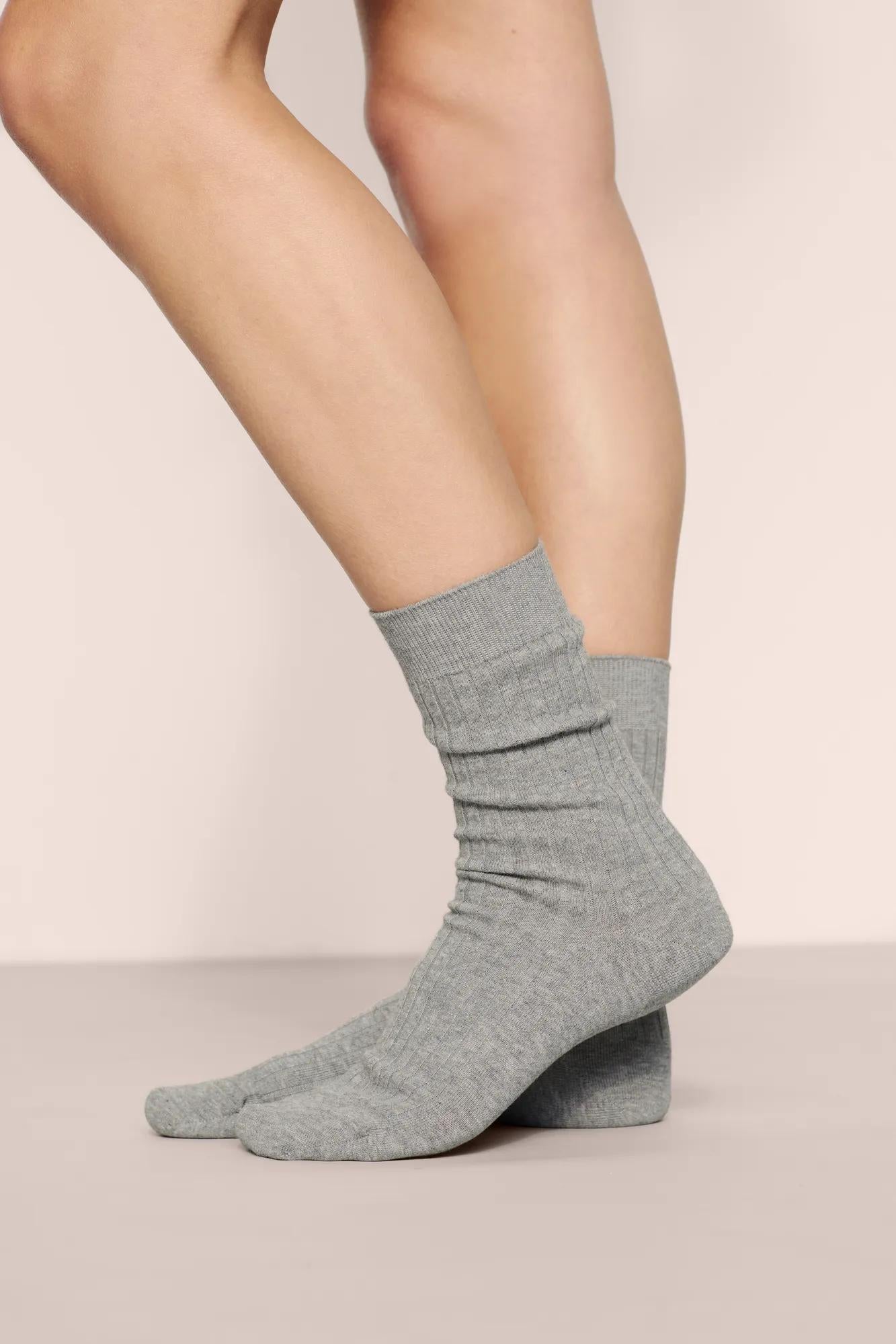 Model is wearing Essential Rib Socks in Dark Heather Grey