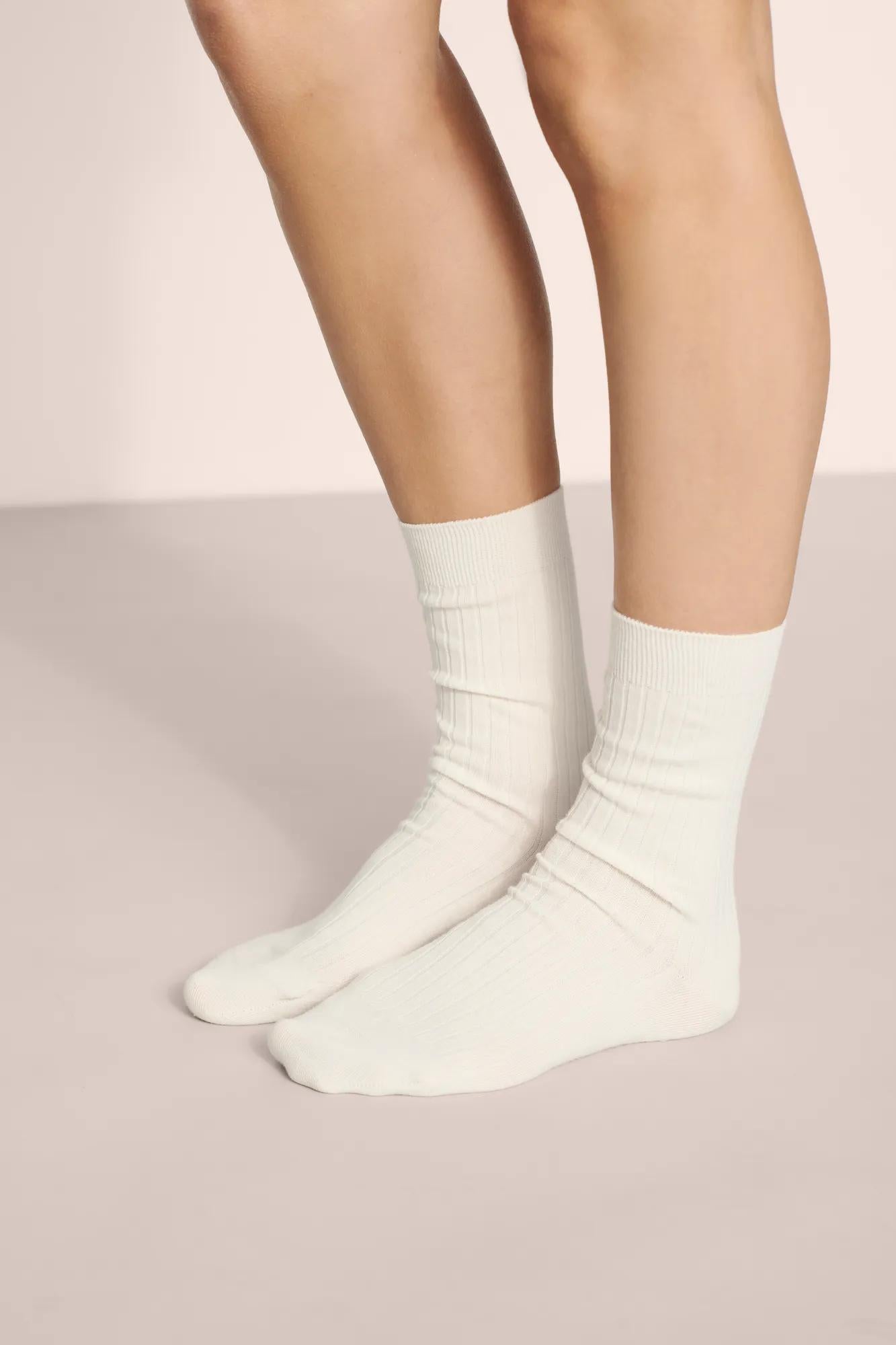 Model is wearing Essential Rib Socks in Ivory
