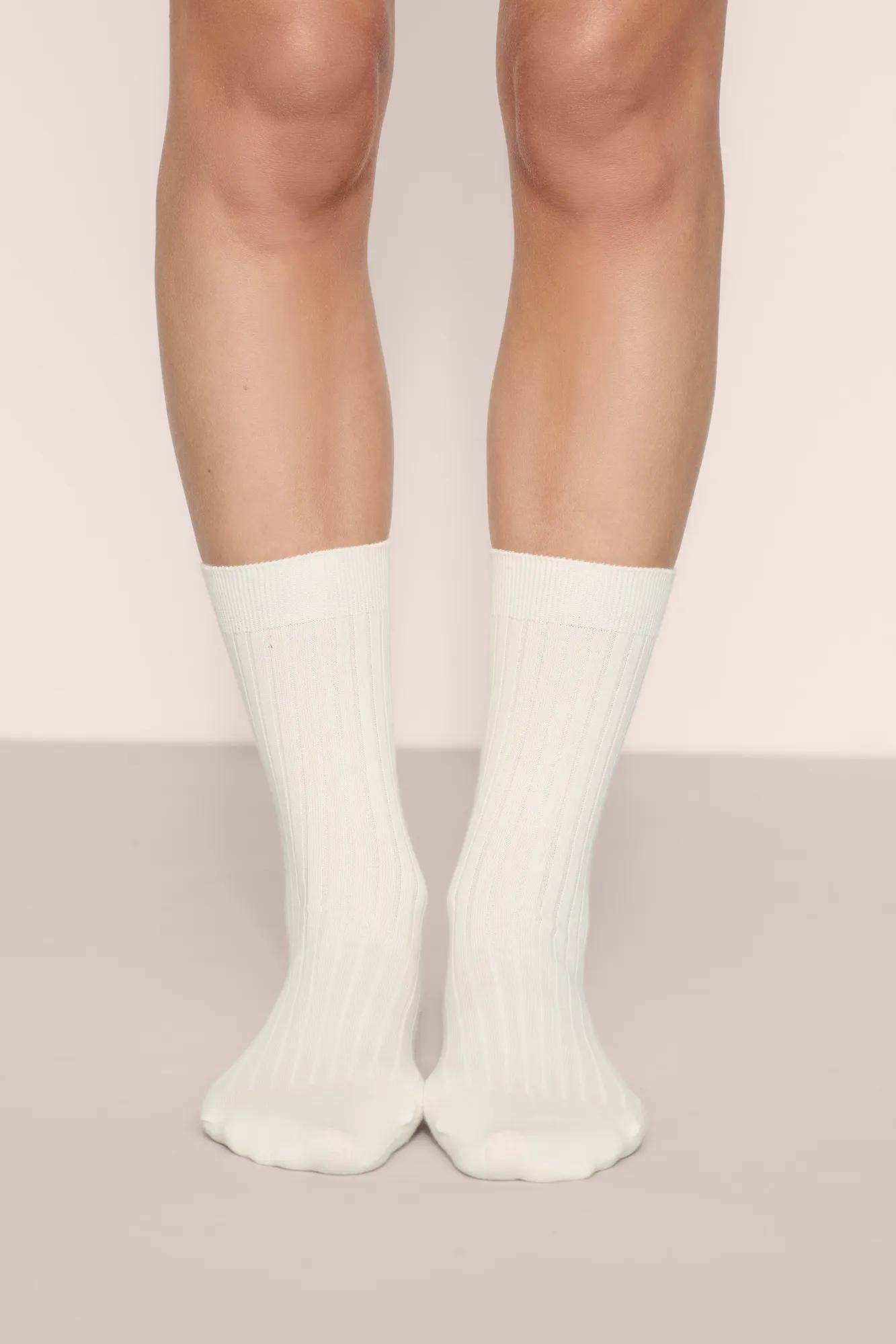 Model is wearing Essential Rib Socks in Ivory