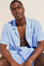 Model wears Men's Organic Sandwashed Cotton Short PJ Set in Nautico Stripe Azure.